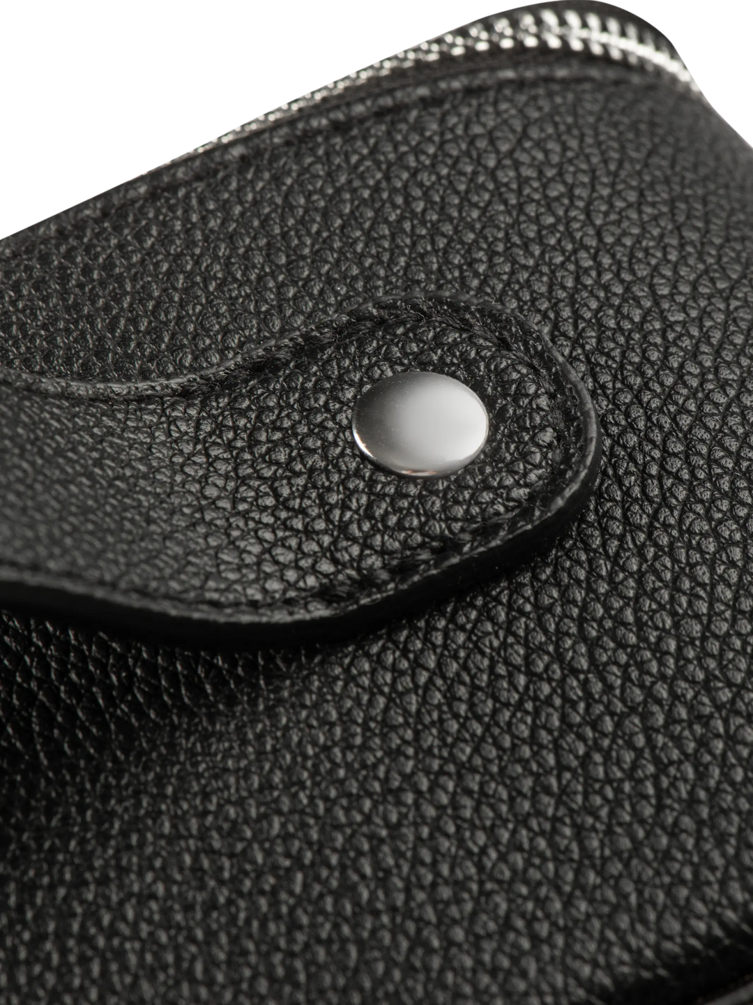 Close-up of a black textured leather product with a silver button on a white background